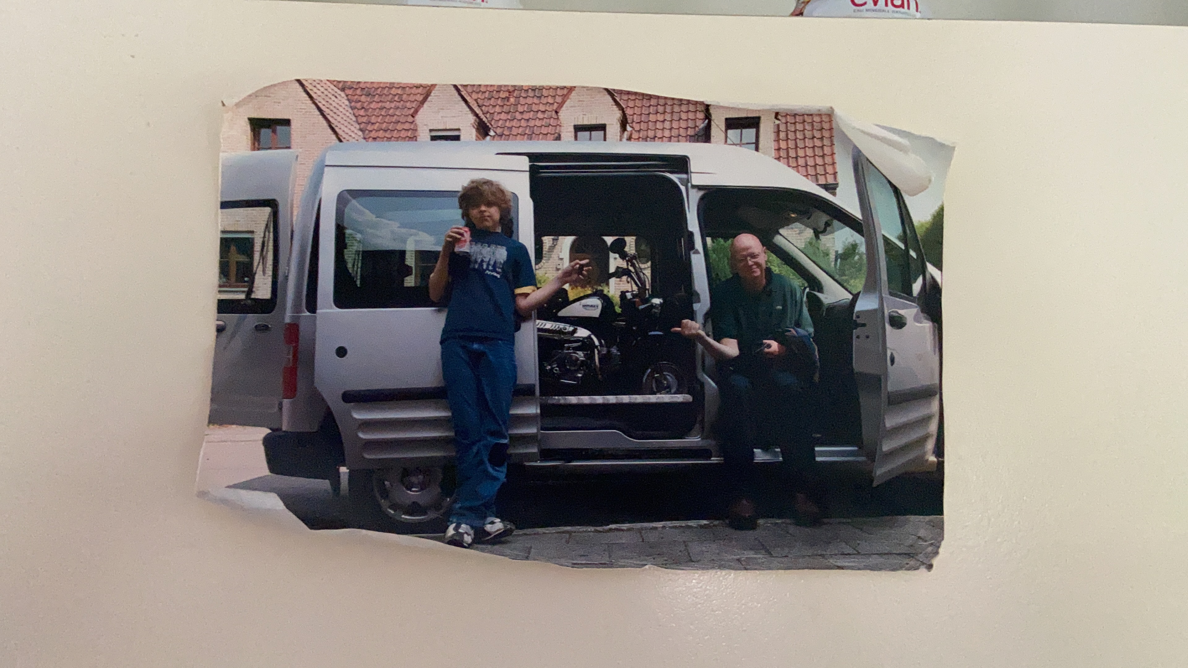 A family archive photograph beside a van carrying a small motorcycle